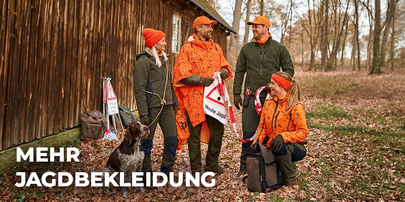 Jäger in Tarnkleidung steht mit einem Gewehr neben seinem Hund in einem sonnendurchfluteten Nadelwald; links unten steht der Schriftzug ‚Mehr Jagdbekleidung‘.
